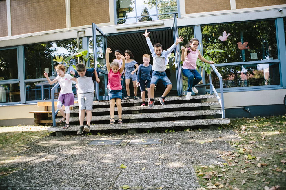 Kinder rennen aus einem Schulgebäude raus